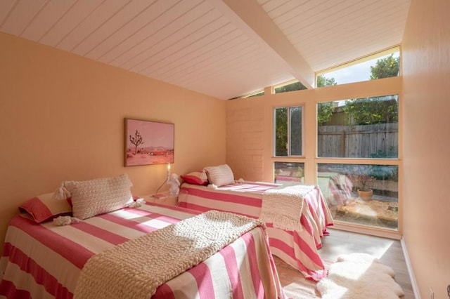 bedroom with hardwood / wood-style floors and vaulted ceiling with beams