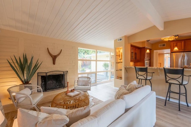 living room featuring a fireplace, vaulted ceiling with beams, light hardwood / wood-style floors, and wood ceiling