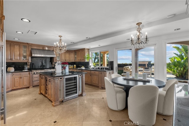 kitchen with ventilation hood, wine cooler, a kitchen island, and a wealth of natural light