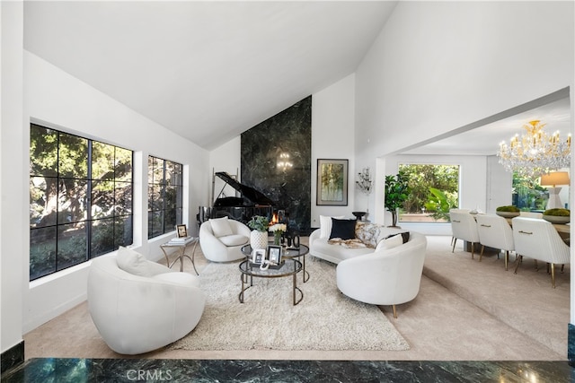 carpeted living room with an inviting chandelier and high vaulted ceiling