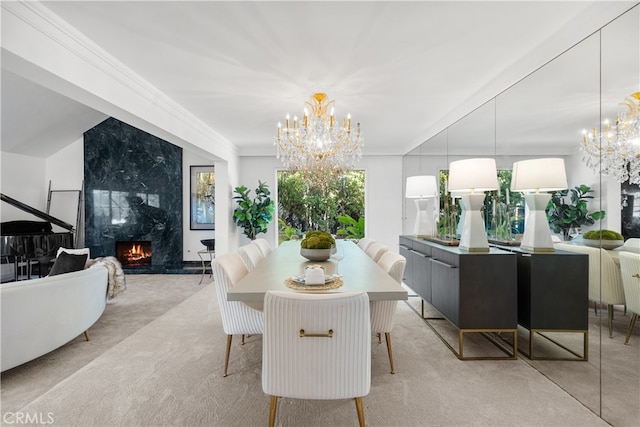 carpeted dining space with a premium fireplace, a chandelier, and ornamental molding