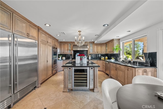 kitchen featuring extractor fan, stainless steel appliances, decorative light fixtures, beverage cooler, and decorative backsplash