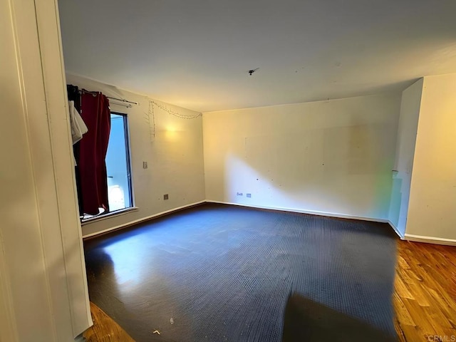 unfurnished room with baseboards