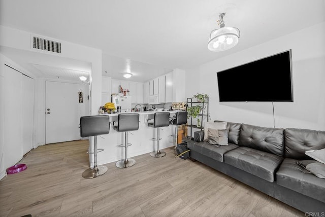 living room featuring light wood-type flooring and visible vents