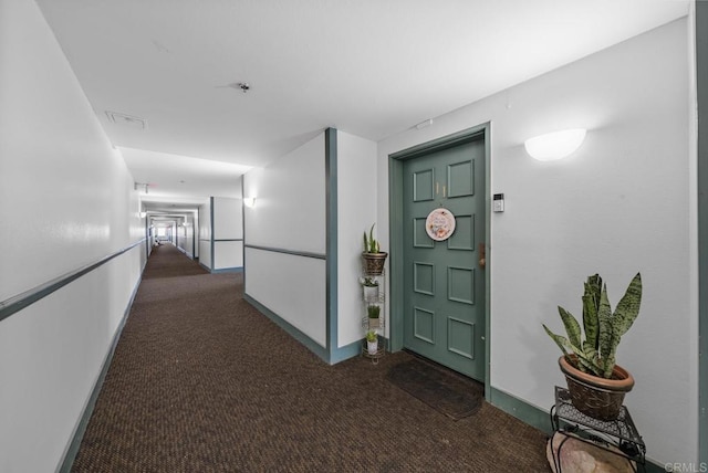 corridor featuring carpet flooring, visible vents, and baseboards