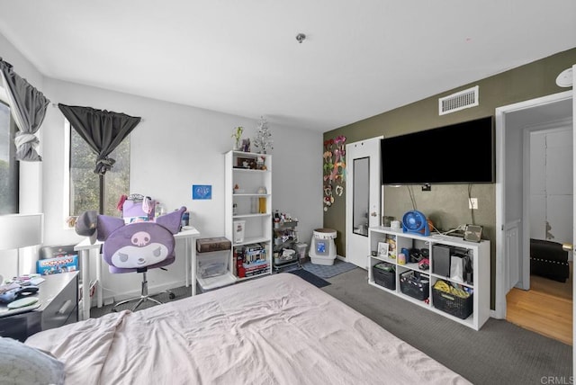 carpeted bedroom featuring visible vents