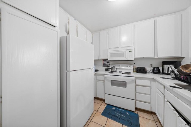 kitchen featuring light countertops, white appliances, light tile patterned flooring, and white cabinets