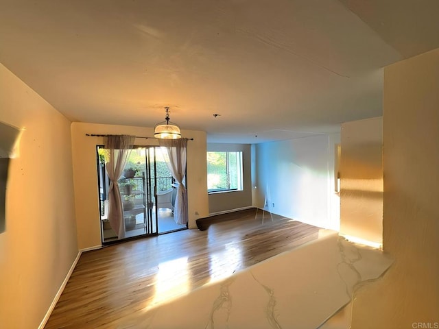 unfurnished room with wood finished floors and baseboards