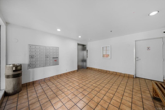 empty room with recessed lighting, elevator, baseboards, and mail area