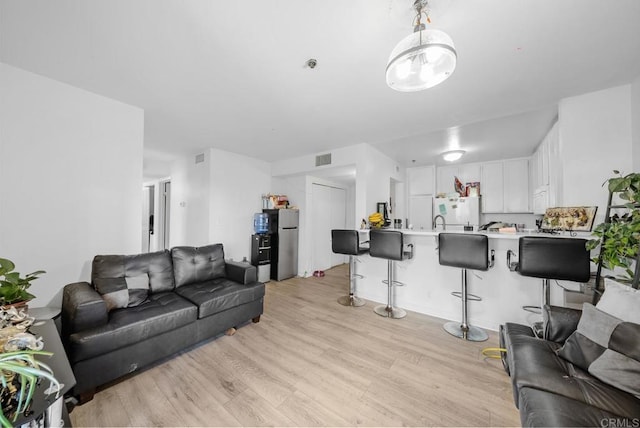 living room featuring light wood finished floors and visible vents