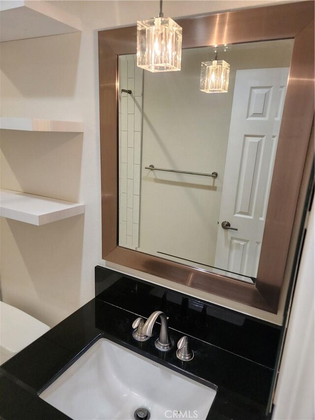 bathroom with a notable chandelier and a sink