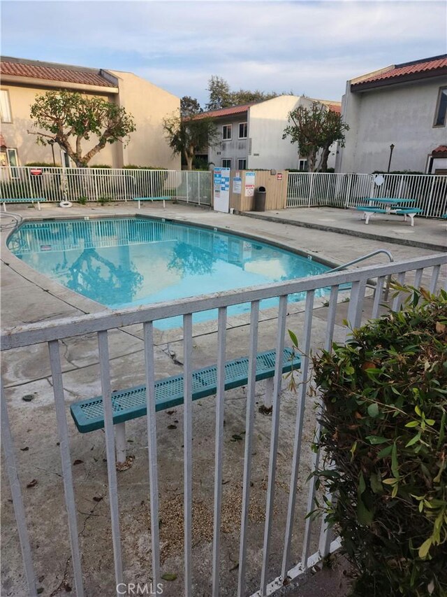 community pool featuring fence and a patio area