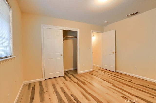 unfurnished bedroom featuring light wood-type flooring and a closet