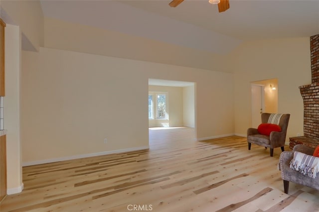 sitting room with ceiling fan, light hardwood / wood-style floors, and high vaulted ceiling