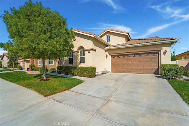 mediterranean / spanish house with a front yard and a garage