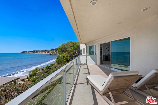 balcony with a water view and a beach view