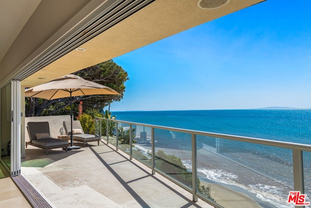 balcony featuring a water view and a view of the beach