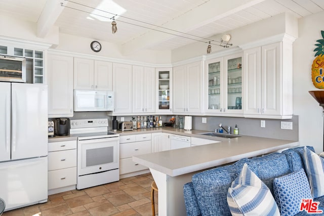 kitchen featuring kitchen peninsula, white cabinetry, beamed ceiling, sink, and white appliances