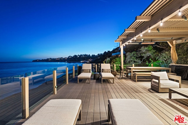 wooden terrace with a water view and outdoor lounge area