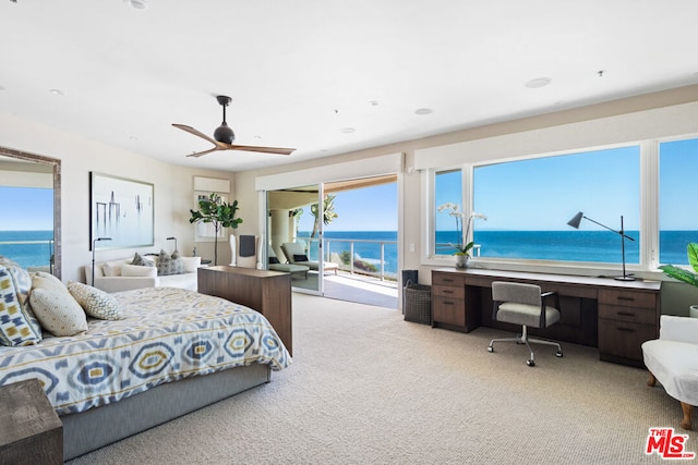 carpeted bedroom with built in desk, a water view, access to exterior, and ceiling fan