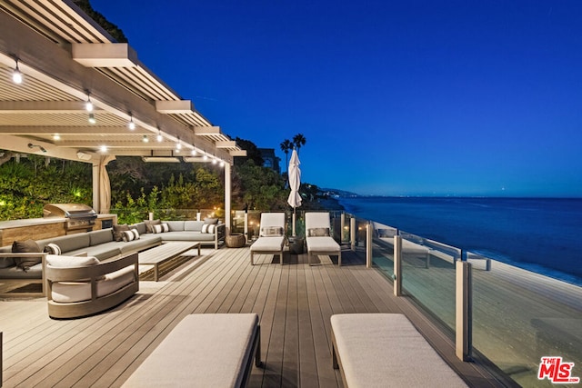 deck at twilight with a pergola, an outdoor living space, a water view, and a grill