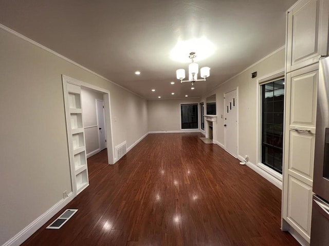 empty room featuring a chandelier, crown molding, and dark hardwood / wood-style floors