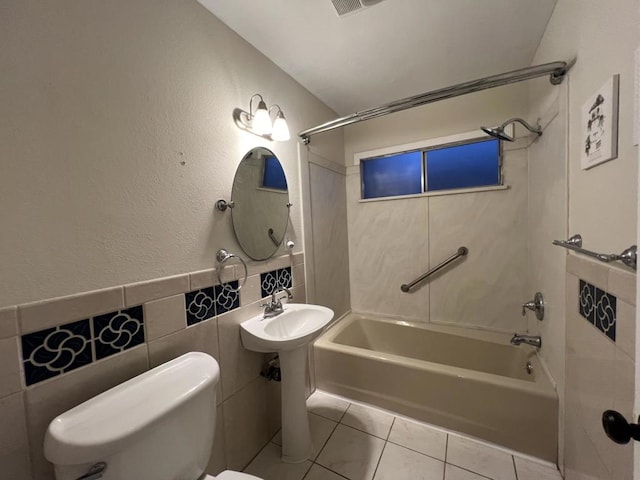 full bathroom with bathing tub / shower combination, tile patterned floors, sink, tile walls, and toilet