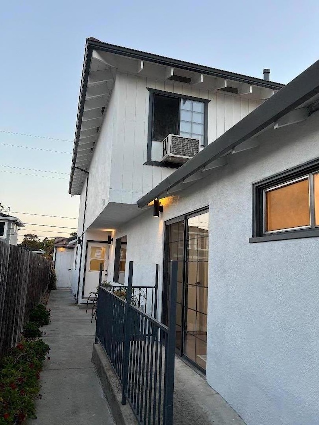 property exterior at dusk featuring cooling unit