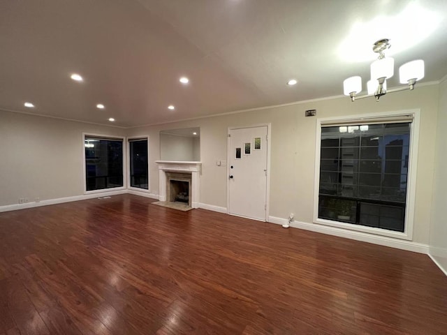 unfurnished living room with ornamental molding, a chandelier, and dark hardwood / wood-style flooring