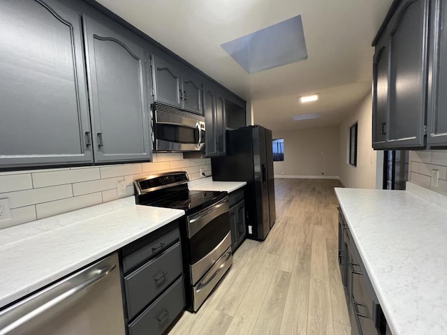 kitchen featuring decorative backsplash, light hardwood / wood-style flooring, and stainless steel appliances