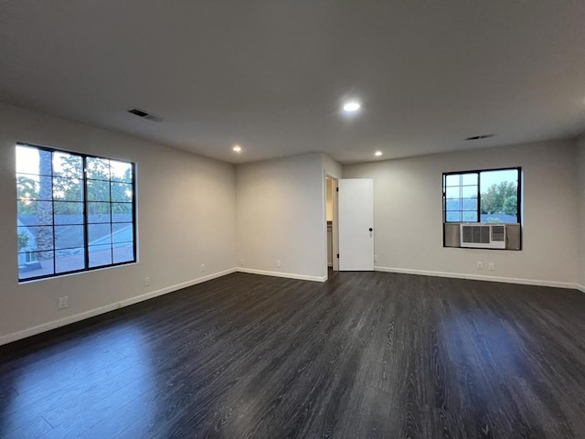 spare room with cooling unit and dark wood-type flooring