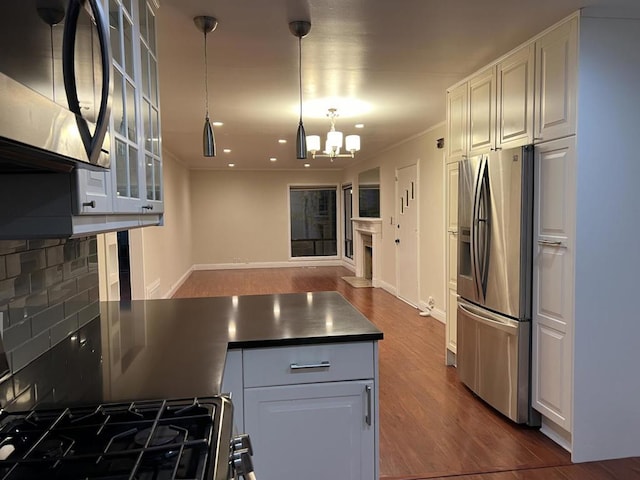 kitchen with hanging light fixtures, dark hardwood / wood-style flooring, white cabinets, a chandelier, and stainless steel appliances