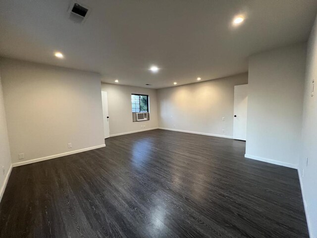 spare room with cooling unit and dark hardwood / wood-style flooring