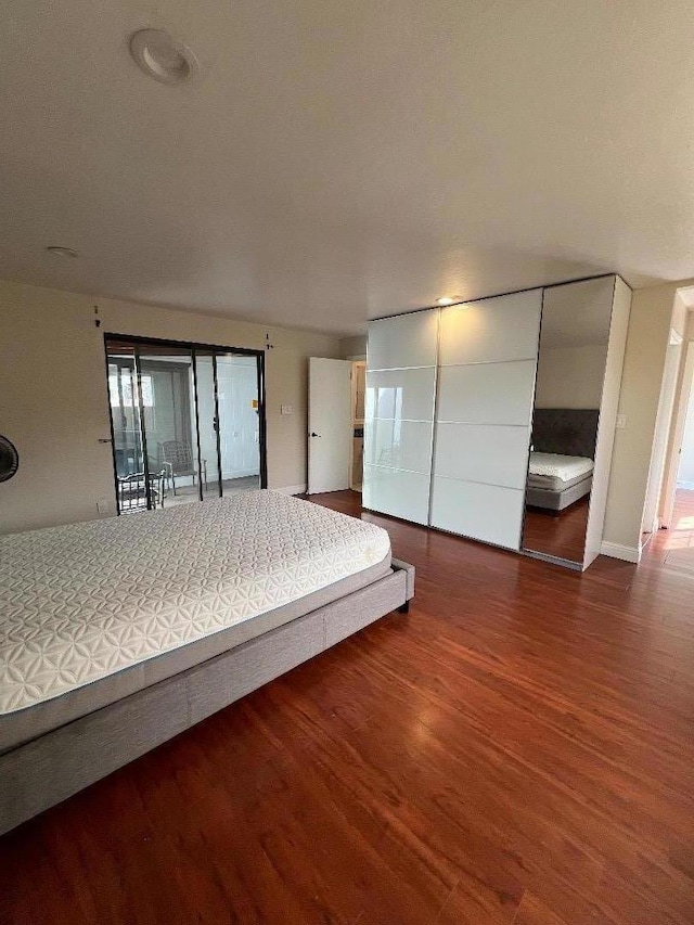 unfurnished bedroom featuring a closet and dark wood-type flooring