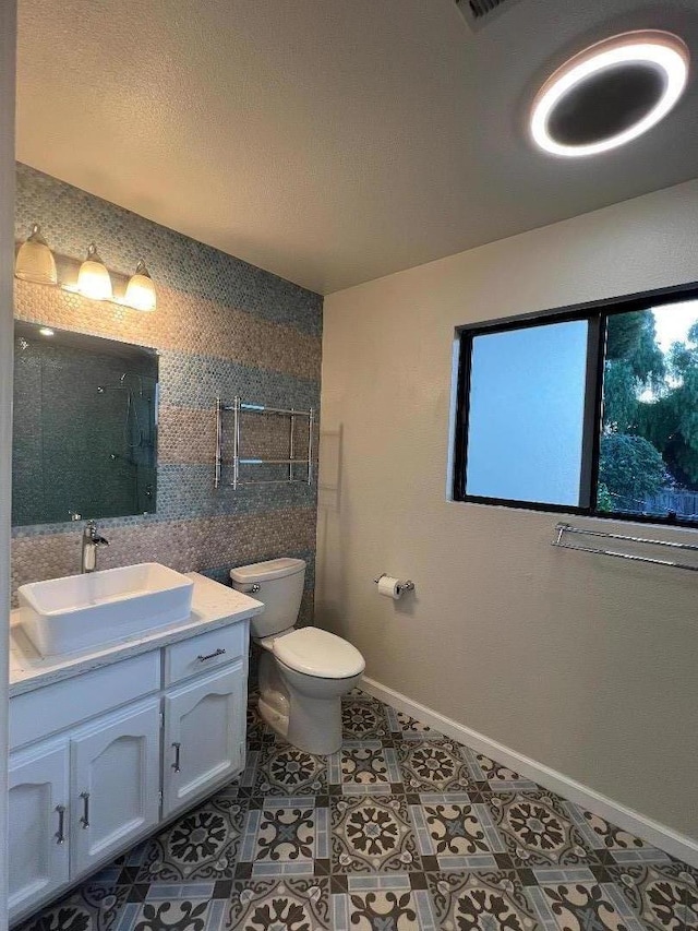 bathroom featuring vanity, toilet, a shower, and tile patterned floors