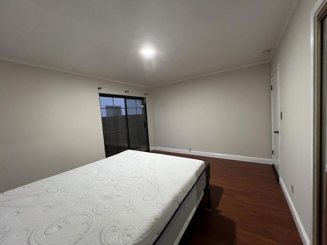 bedroom with dark wood-type flooring and crown molding