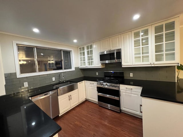 kitchen featuring crown molding, dark hardwood / wood-style flooring, sink, appliances with stainless steel finishes, and white cabinetry