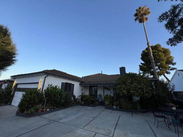 view of front of property with a garage and a patio area