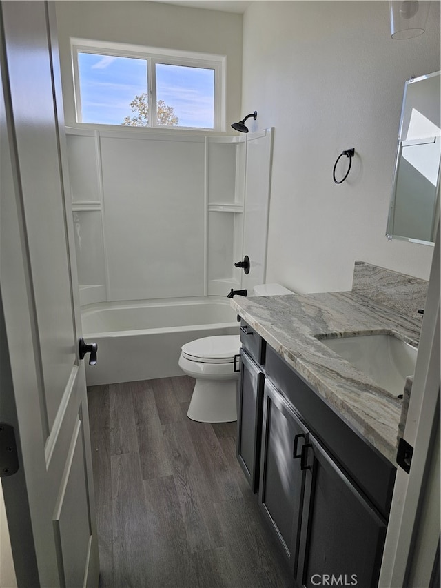 full bathroom featuring bathtub / shower combination, vanity, wood-type flooring, and toilet