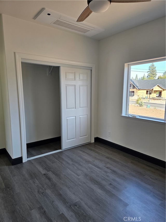 unfurnished bedroom featuring dark hardwood / wood-style floors, a closet, and ceiling fan