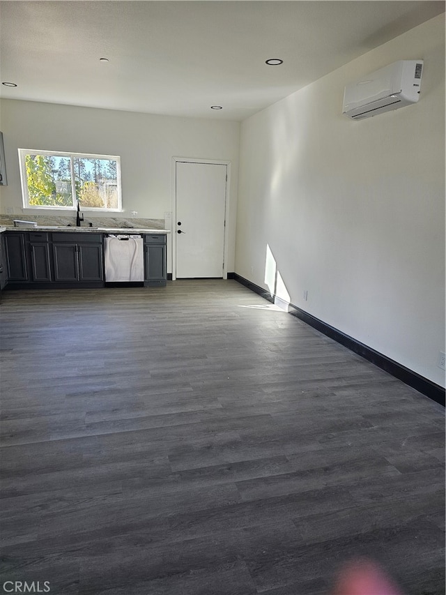 interior space with a wall unit AC, sink, and dark hardwood / wood-style flooring