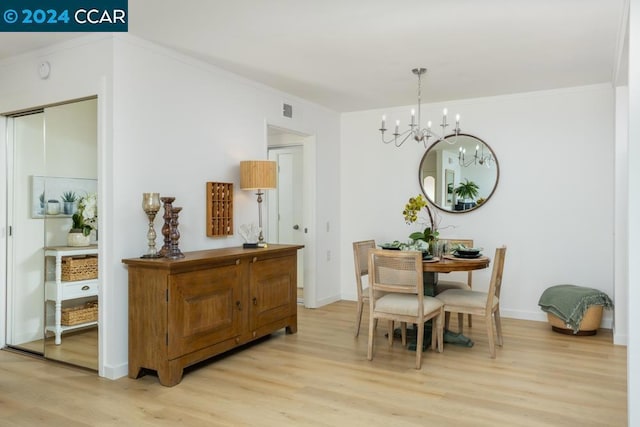 dining room with a chandelier, crown molding, and light hardwood / wood-style floors