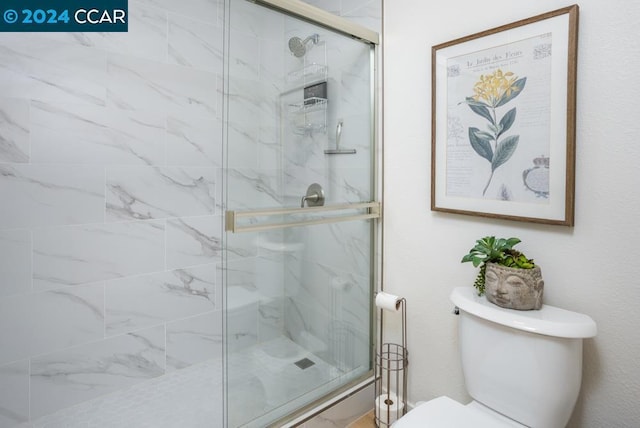 bathroom featuring an enclosed shower and toilet