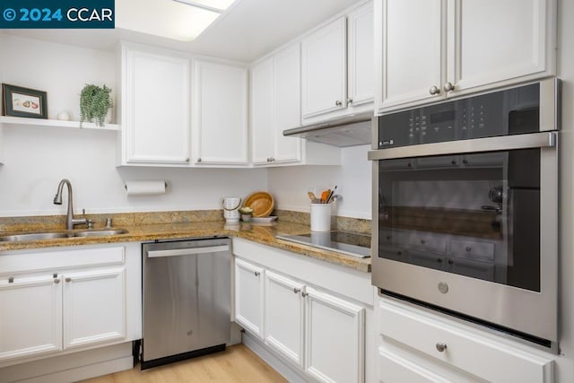 kitchen featuring appliances with stainless steel finishes, white cabinetry, and sink