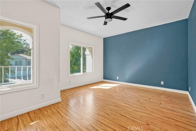 spare room featuring a ceiling fan, baseboards, and wood finished floors