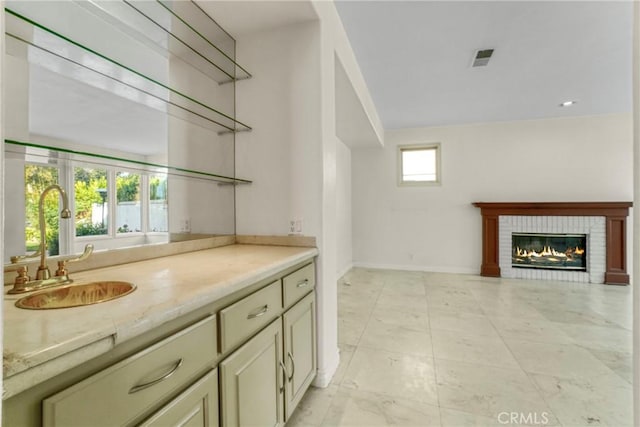 bar featuring a fireplace, a sink, visible vents, and baseboards