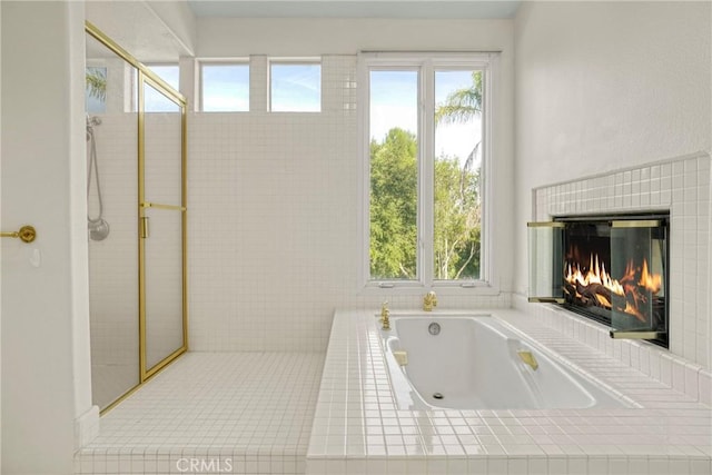 bathroom with a garden tub, a tile shower, and a tile fireplace