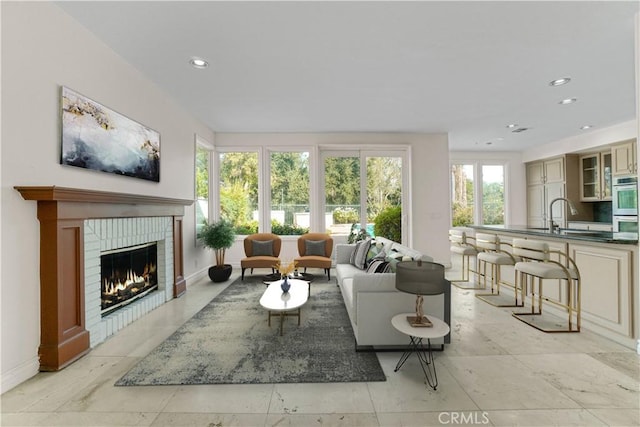 living area with a fireplace, baseboards, and recessed lighting