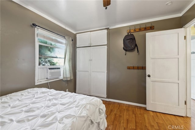 bedroom featuring a closet, ceiling fan, hardwood / wood-style flooring, and cooling unit