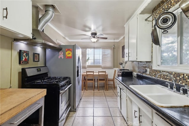 kitchen with stainless steel appliances, backsplash, sink, light tile patterned flooring, and white cabinets